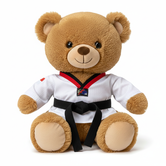 Teddy bear in a martial arts Taekwondo uniform with a black belt on a white background