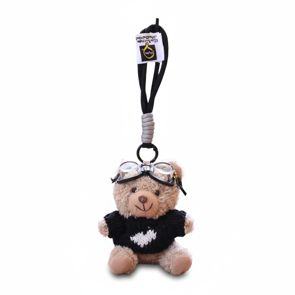 Teddy bear keychain with goggles and black sweater on a white background