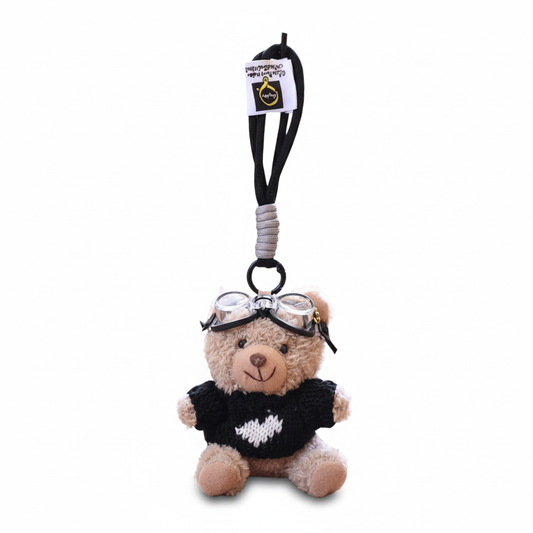 Teddy bear keychain with goggles and black sweater on a white background