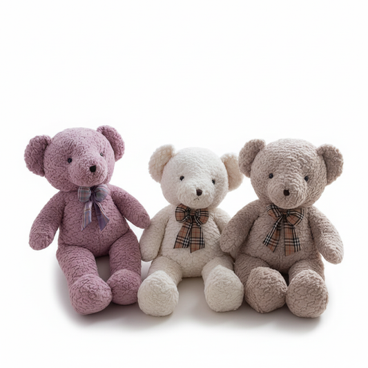 Three teddy bears in pink, white, and beige with plaid ribbons on a white background