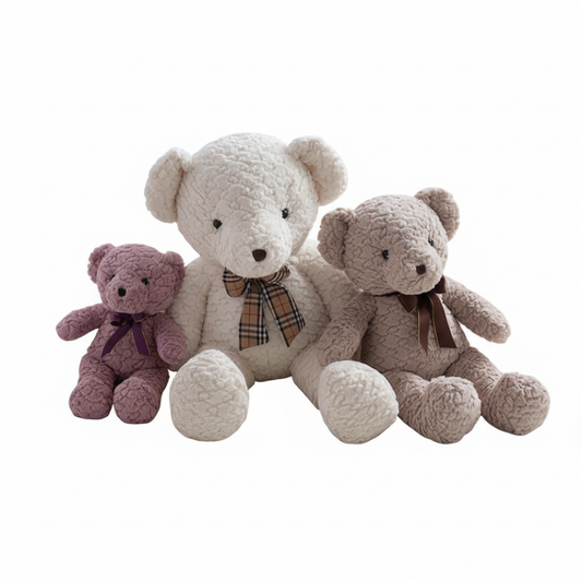 Three teddy bears in different colors sitting together on a white background